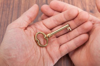 birinin elini altın anahtar tutan ahşap tablo
