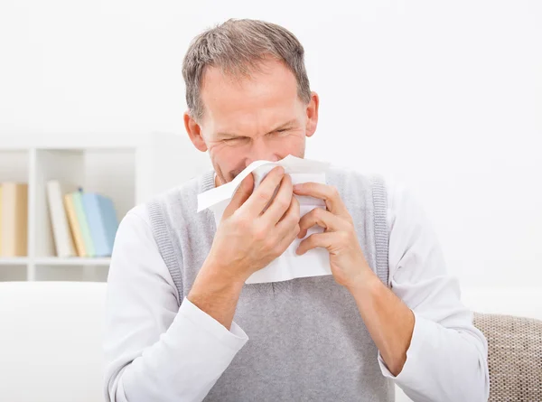 Mann pustet sich die Nase aus — Stockfoto