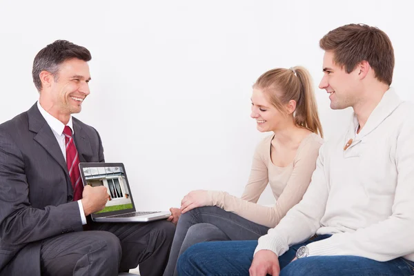 Estate Agent Showing Laptop To Couple — Stok fotoğraf