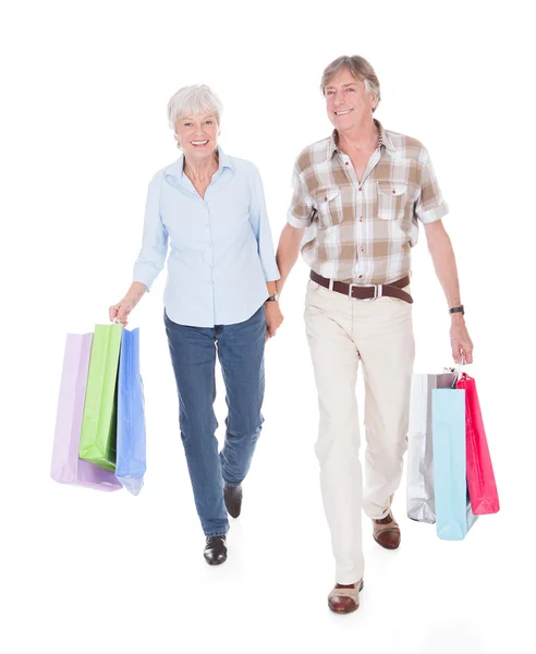 Senioren paar wandelen met boodschappentas — Stockfoto