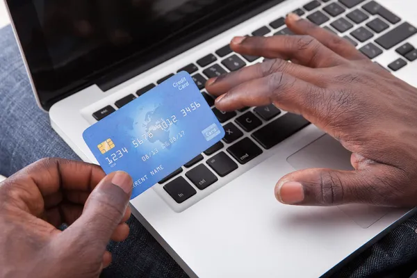 Hand hält Kreditkarte mit Laptop — Stockfoto