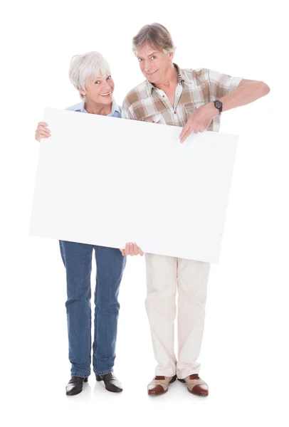 Starší pár s bílou tabuli — Stock fotografie