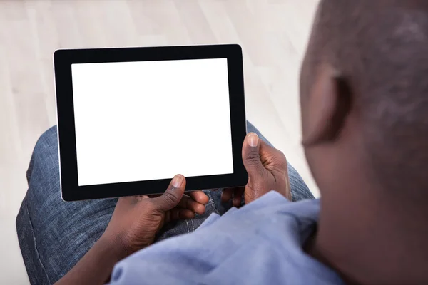 Африканська людина сидить з цифровим планшетом — стокове фото