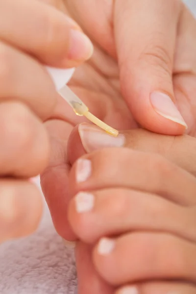 Kosmetolog gäller nagellack för kvinna — Stockfoto