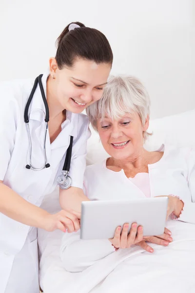 Médico mostrando tablet digital para paciente — Fotografia de Stock