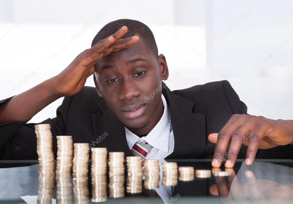Worried Businessman Looking At Coins