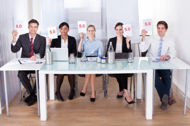 Businesspeople In Conference Holding Paper clipart