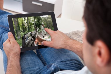 Tablet PC'de oyun oynayan adam