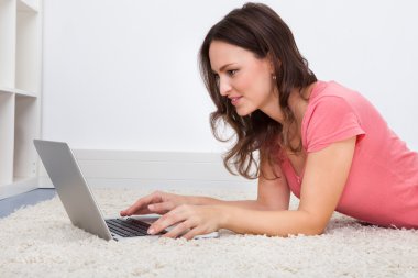 laptop önünde yatan kadın