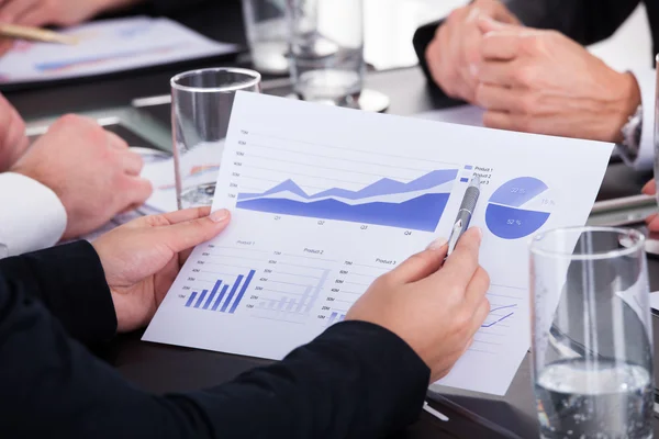 Бизнесмен держит ручку на графике на деловой встрече — стоковое фото