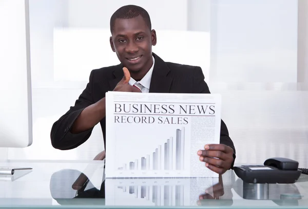 Empresário mostrando jornal — Fotografia de Stock