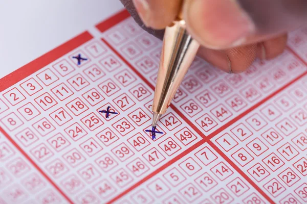 Person markiert Zahl auf Lottoschein — Stockfoto