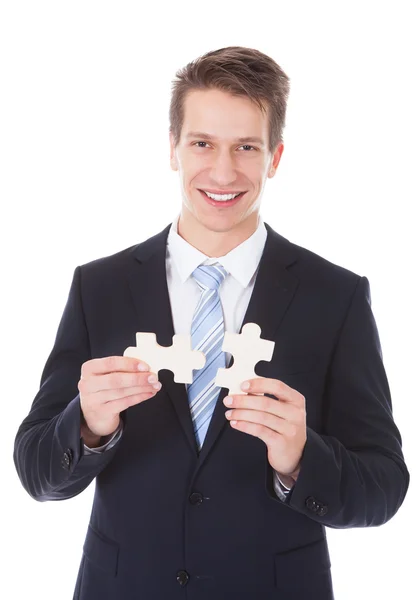 Jonge zakenman bedrijf jigsaw puzzle — Stockfoto