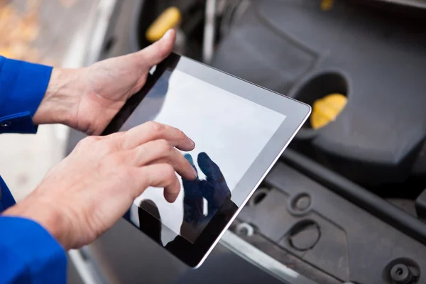 Meccanico dell'automobile facendo uso della compressa digitale — Foto Stock