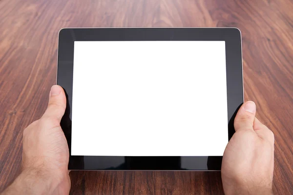 Mano de la persona en la tabla de madera que sostiene la tableta digital — Foto de Stock