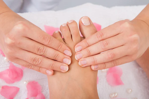 Piedi della donna che ricevono massaggio ai piedi — Foto Stock