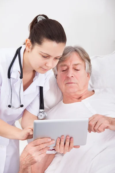 Врач и пациент смотрит на цифровой планшет — стоковое фото