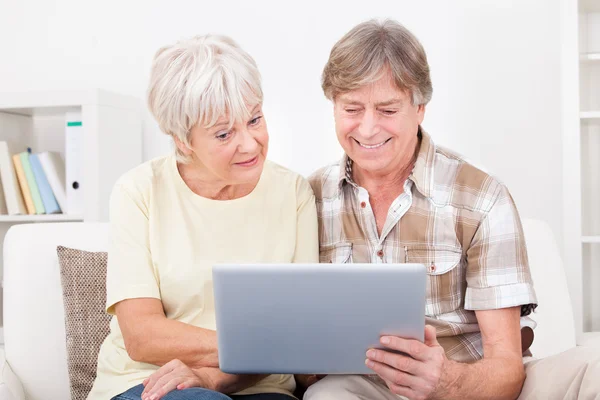 Äldre par tittar på laptop — Stockfoto