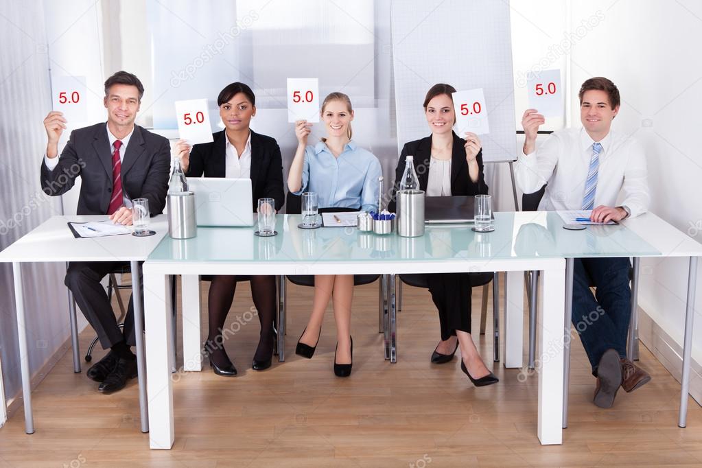 Businesspeople In Conference Holding Paper