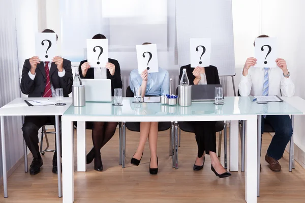 Empresarios con signo de interrogación frente a la cara — Foto de Stock