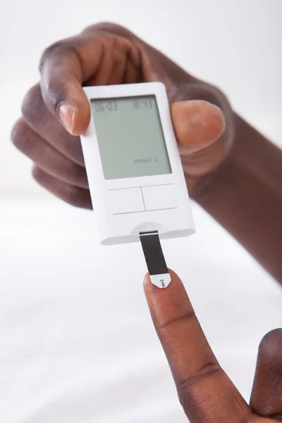 Hand met glucometer — Stockfoto