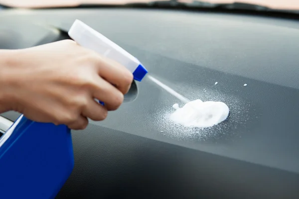 Hand met spray fles spuiten op auto — Stockfoto