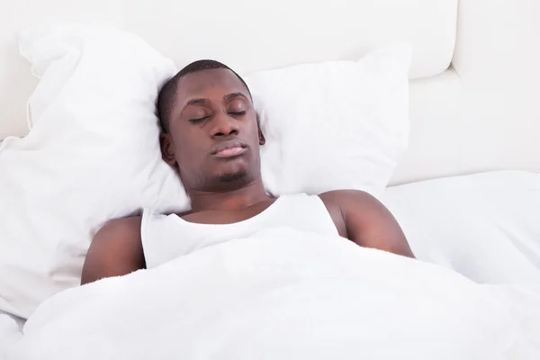 Afrikaanse man slapen op bed — Stockfoto