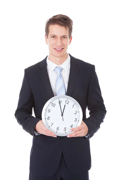 Homme d'affaires tenant horloge sur fond blanc — Photo