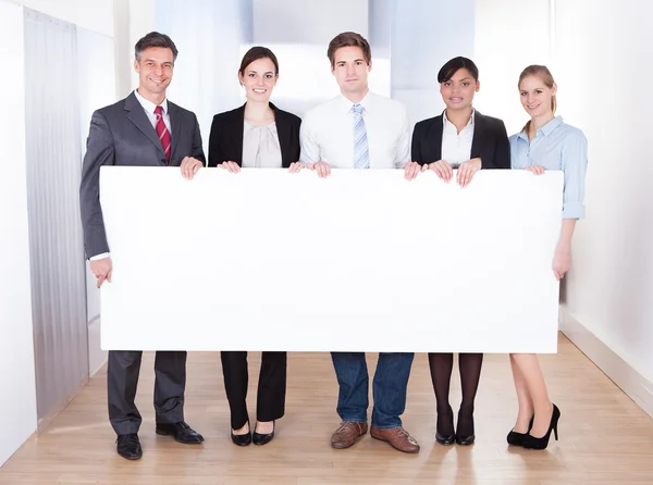 Empresários segurando cartaz em branco — Fotografia de Stock