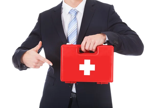 Empresario señalando la caja de primeros auxilios — Foto de Stock