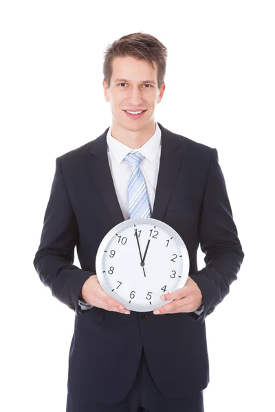 Businessman Holding Clock Over White Background Stock Photo