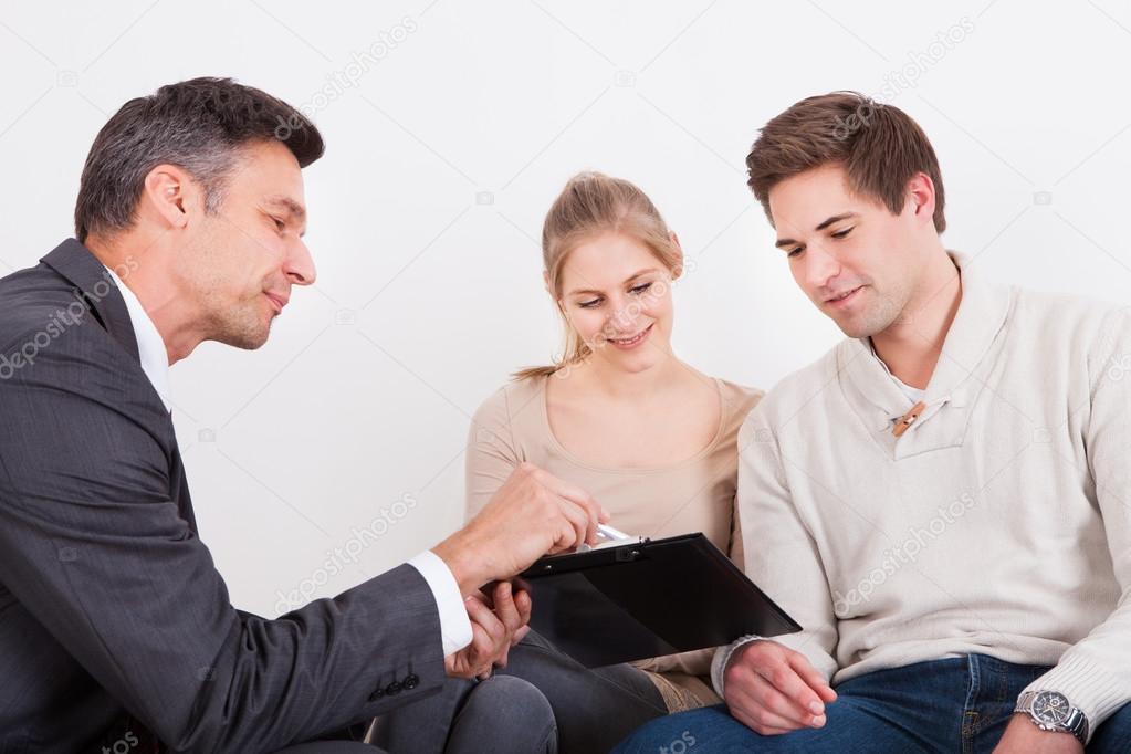 Consultant Showing Clipboard To Couple