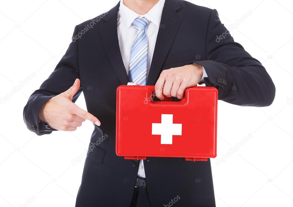 Businessman Pointing At First Aid Box