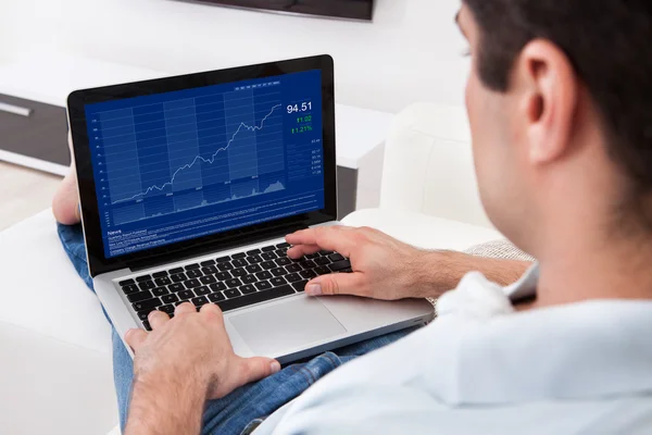 Mann analysiert Grafik auf Laptop — Stockfoto