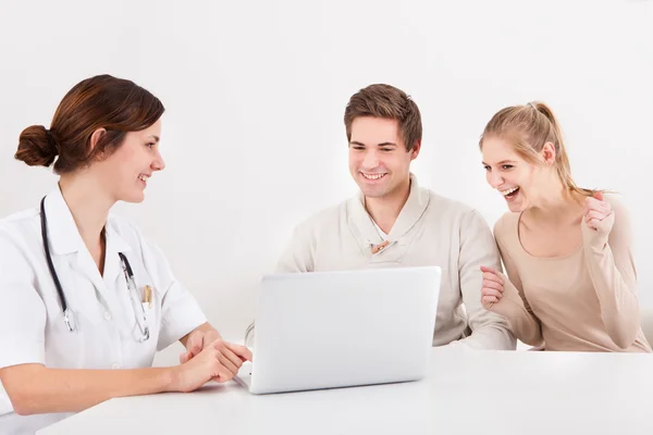 Doutor e casal olhando para laptop — Fotografia de Stock