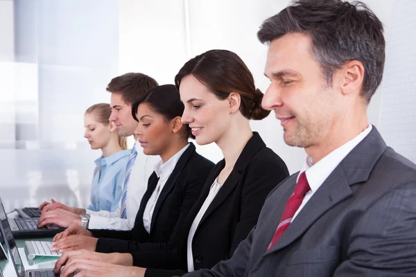 Führungskräfte sitzen in einer Reihe — Stockfoto