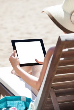 Dijital tablet plaj sandalye kullanan kadın