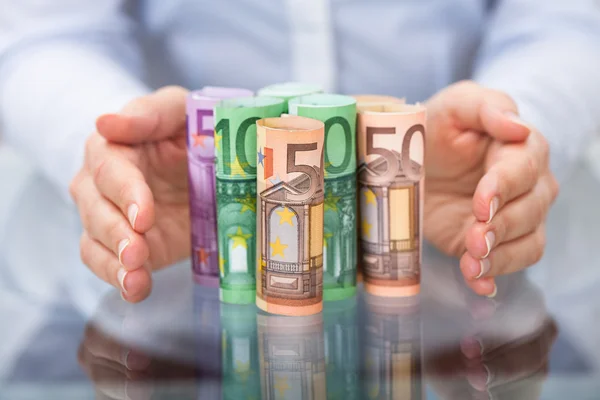 Hand schützt aufgerollte Euro-Banknote — Stockfoto