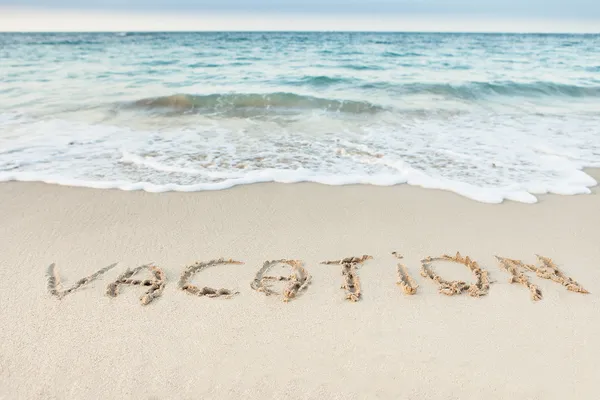 Word Vacation scritto sulla spiaggia — Foto Stock