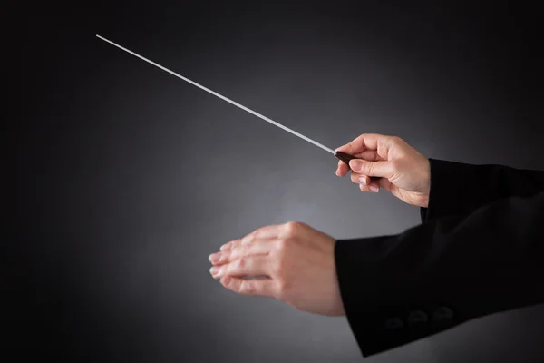 Vrouwelijke orkest dirigent met stokje — Stockfoto