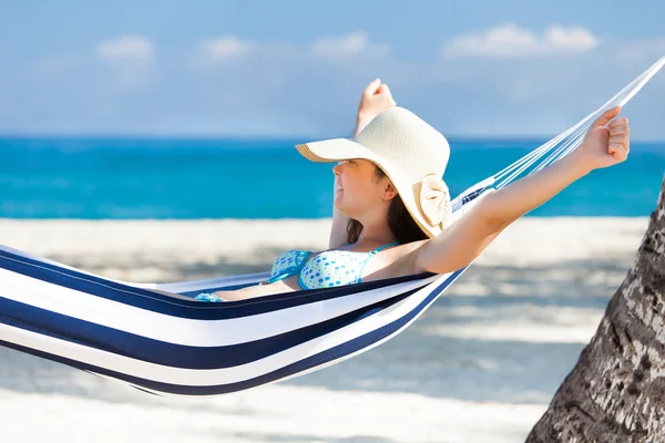 Frau dehnt sich in Hängematte am Strand — Stockfoto