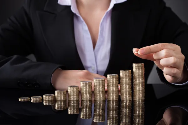 Mujer de negocios con fila de monedas —  Fotos de Stock