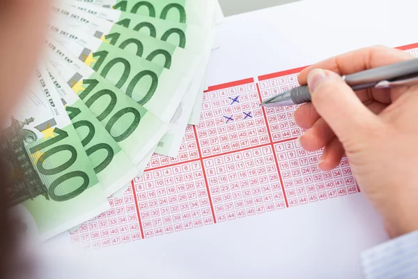 Mano con billete de lotería y billetes — Foto de Stock