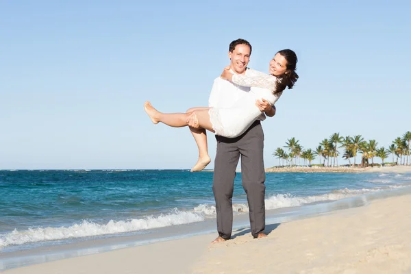 Hombre amoroso llevando a la mujer en la playa —  Fotos de Stock