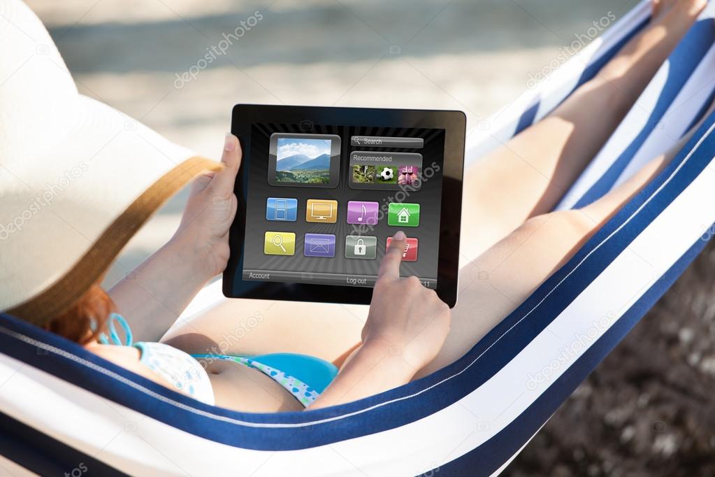 Woman Using Digital Tablet In Hammock