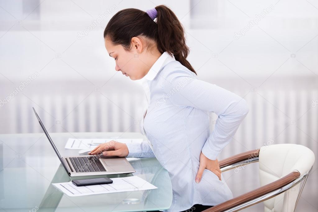 Businesswoman With Laptop Having Back Ache