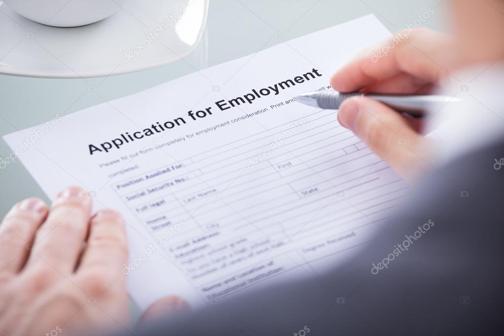 Businessperson With Pen Over Application Form