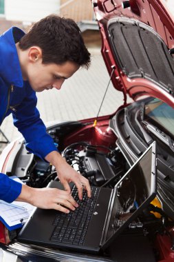 Mechanic laptop gebruikt terwijl het herstel van de auto