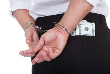 Man in handcuffs with banknotes in his pocket clipart