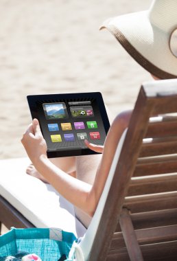 şezlong üzerinde dijital tablet kullanan kadın